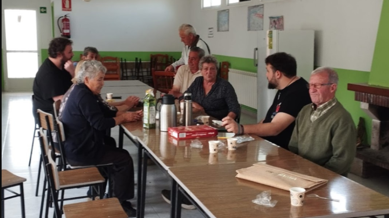 Unas personas toman café alrededor de una mesa