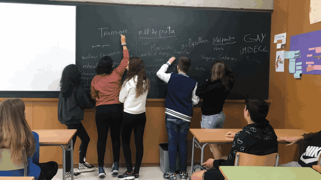 Jóvenes escribiendo palabras en una pizarra de clase