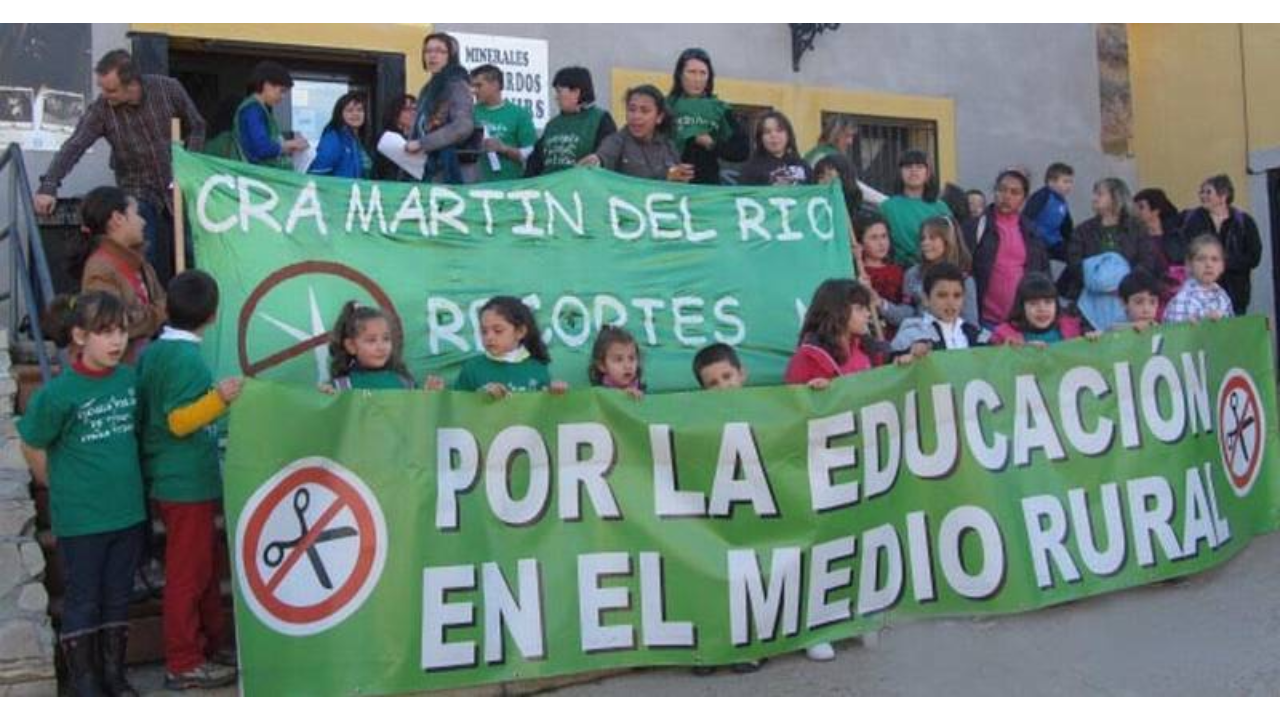 Menores de pie sujetando una pancarta que pone Por la educación en el medio rural