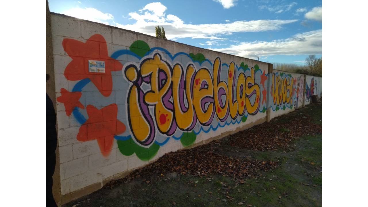 Un mural pintado con un graffiti que se lee la palabra pueblos