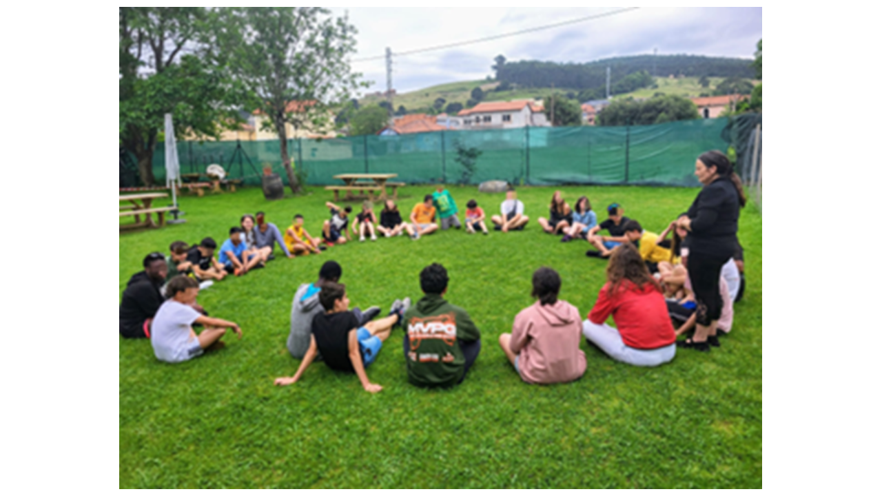 Un grupo de niños sentados en círculo en un jardin