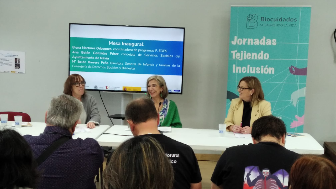 Tres mujeres sentadas en una mesa hablando con un panel detrás de Biocuidados