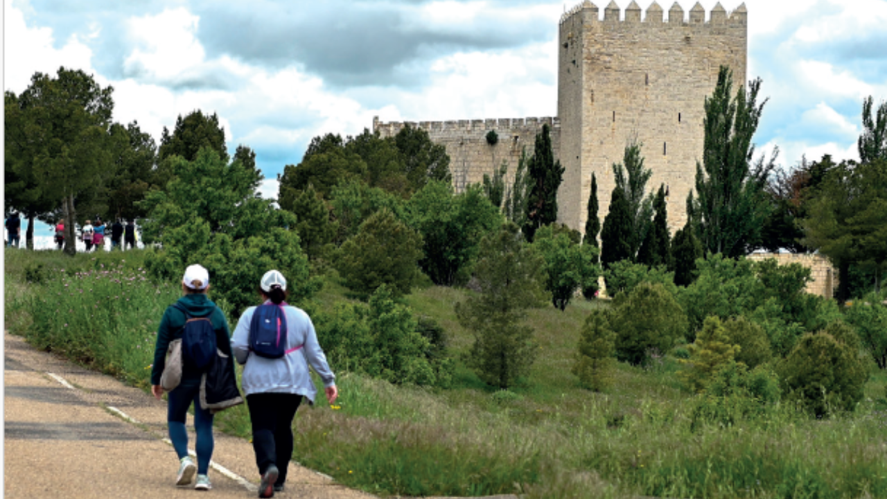 Dos señoras andando de espaldas junto a un castillo